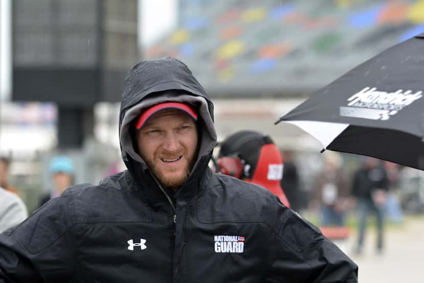 Dale Earnhardt Jr. covers up from the rain as he waits to qualify for the NASCAR Sprint Cup...