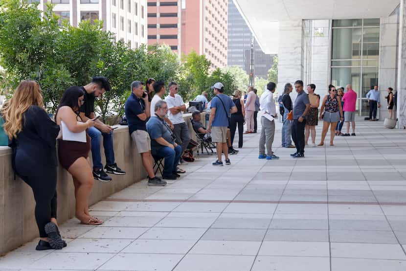 People stand outside the George Allen Courts Building after a water leak, Tuesday, July 2,...