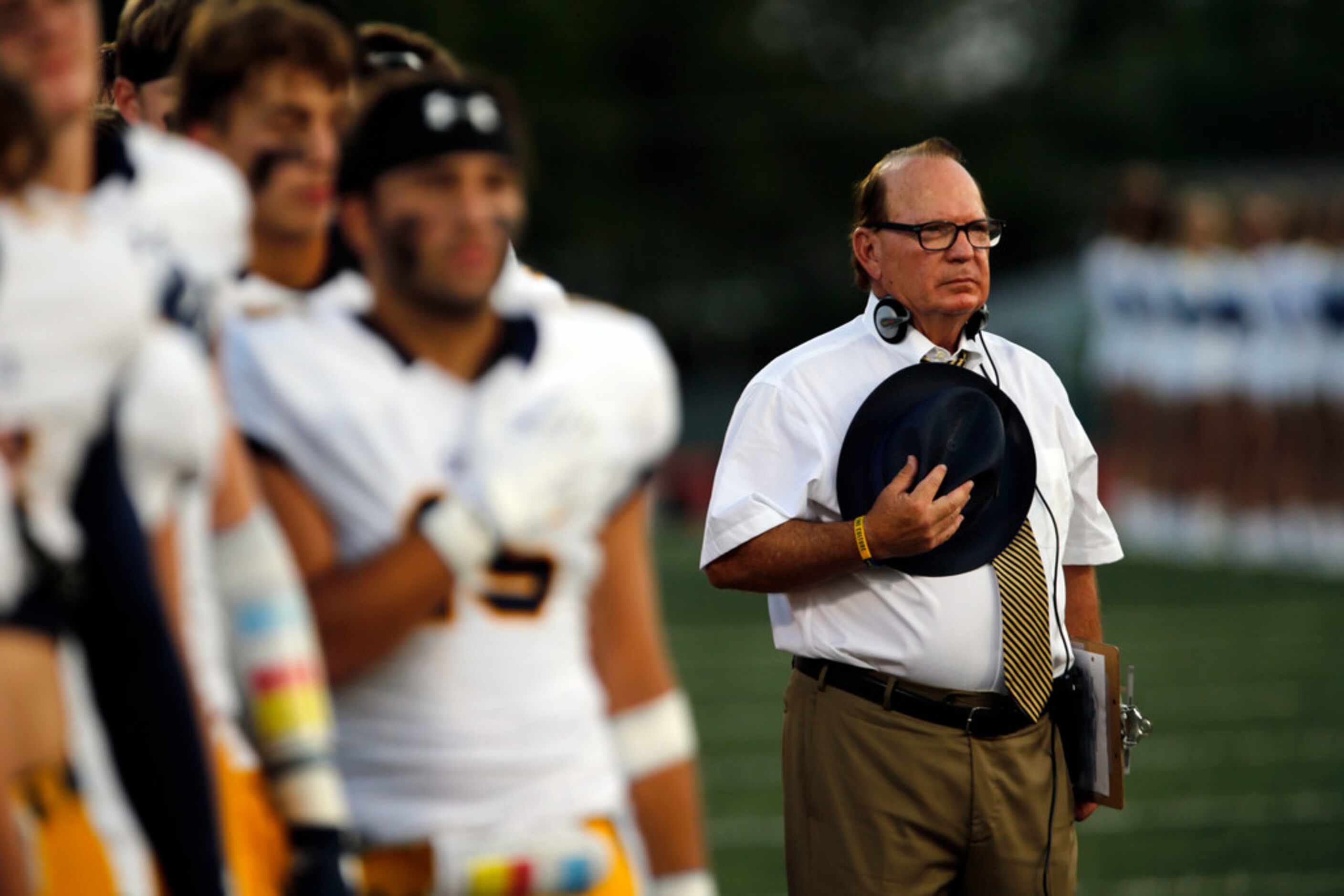 Highland Park coach Randy Allen and his team stand at attention during the national anthum...