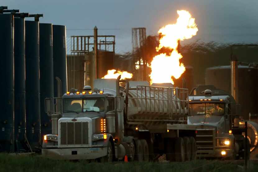Drivers and their tanker trucks, capable of hauling water and hydraulic fracturing liquid,...