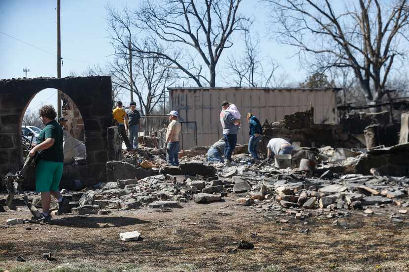The Griffin and Johnson family look through the remains of Mary Griffin’s home on Saturday...