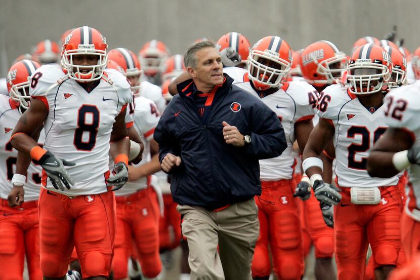 Illinois Head Coach Ron Zook runs onto the field with his team for their Big Ten college...