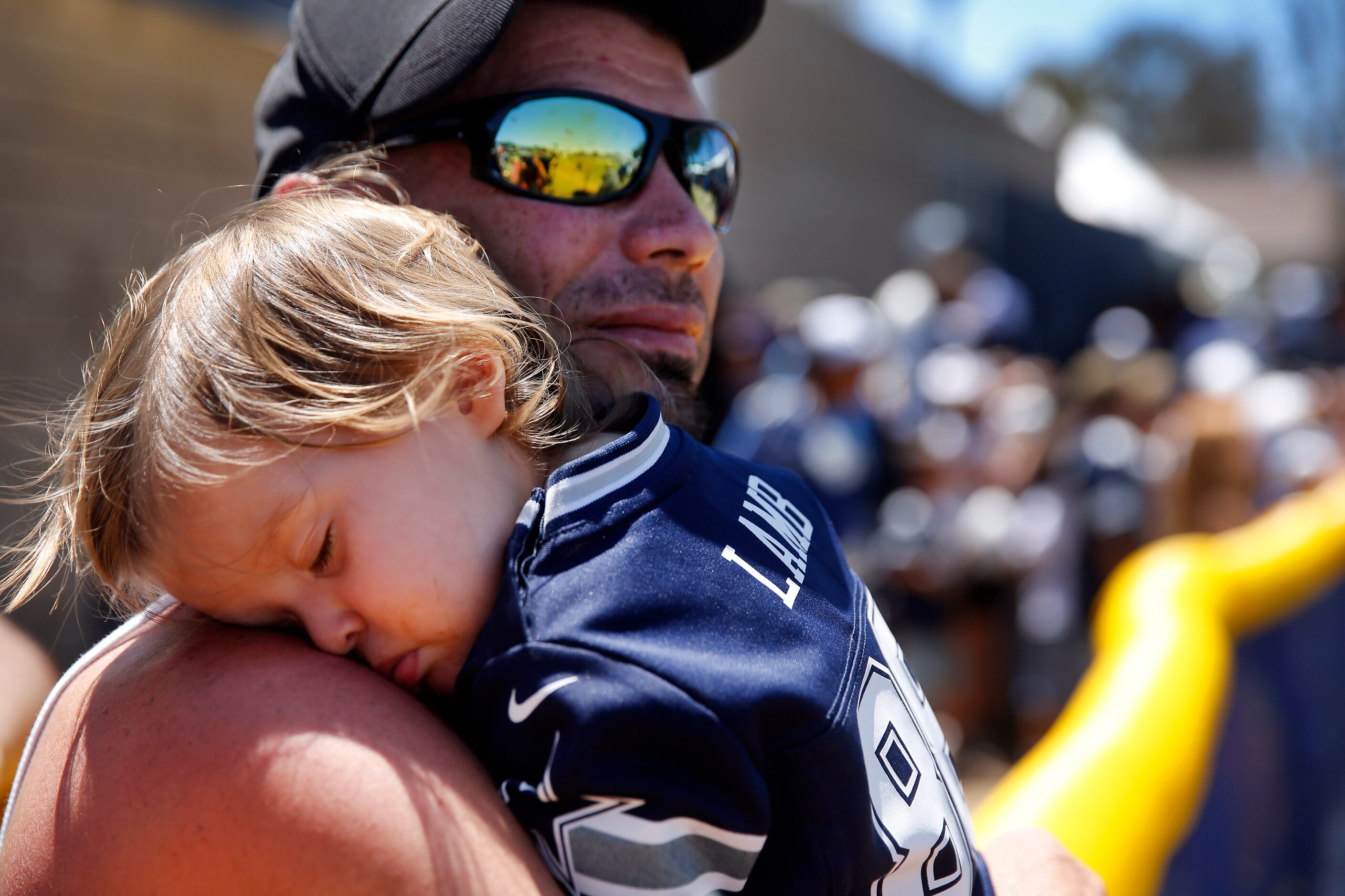 Ava Marie Marchant falls asleep on her father Tre Marchant’s shoulder during training camp...