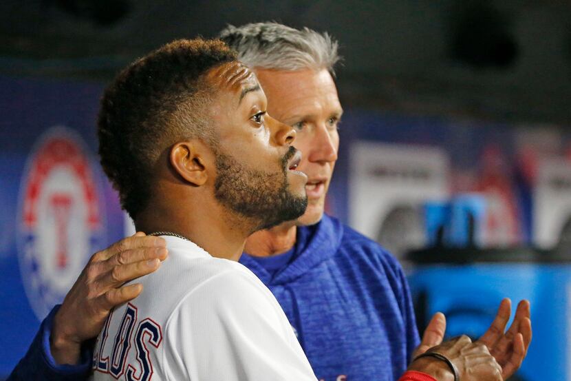 Texas Rangers left fielder Delino DeShields (3) talks about injuring his hand in the dugout...
