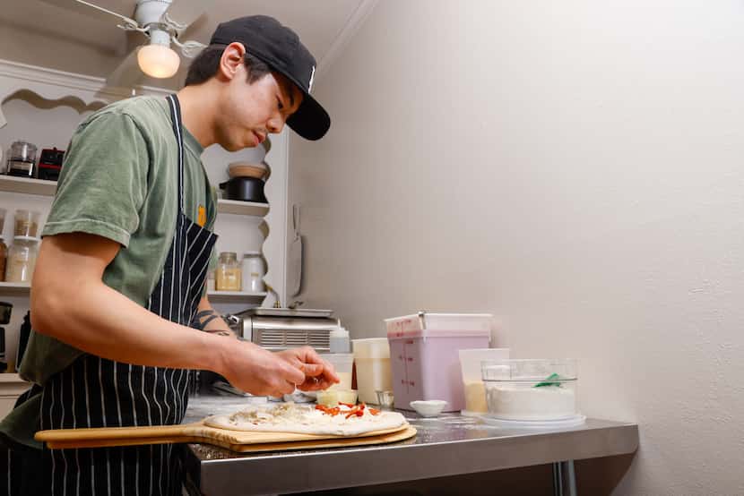 Peter Cho prepares a pepperoni pizza in his apartment’s extended kitchen in Dallas.
