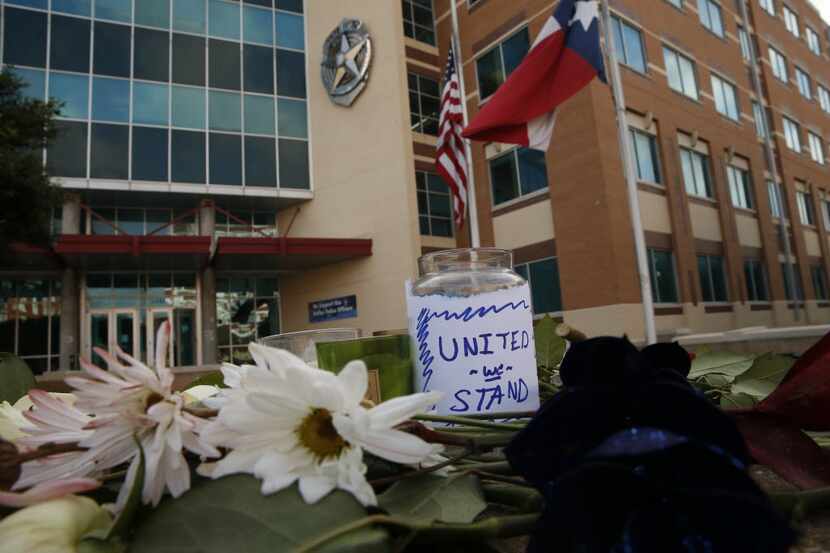 Flowers were left at Jack Evans Police Headquarters in Dallas on Friday after a deadly...