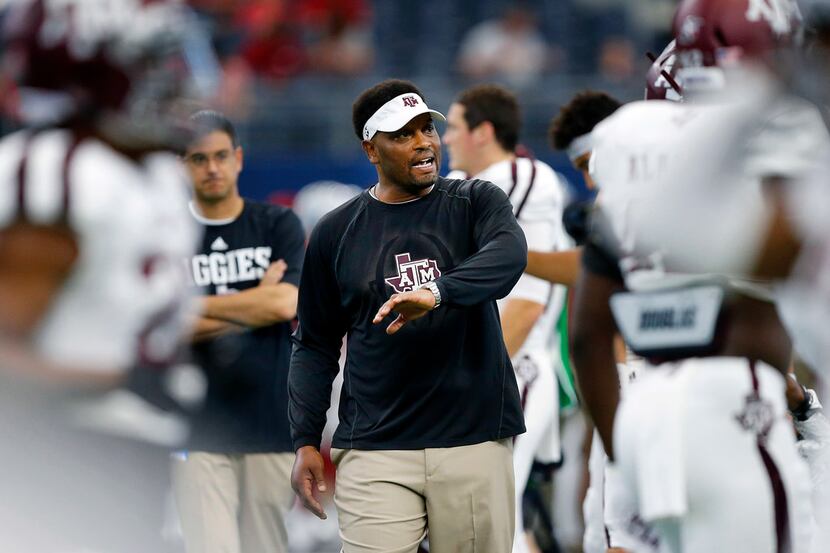 FILE - Texas A&M head coach Kevin Sumlin communicates with his players during pregame...