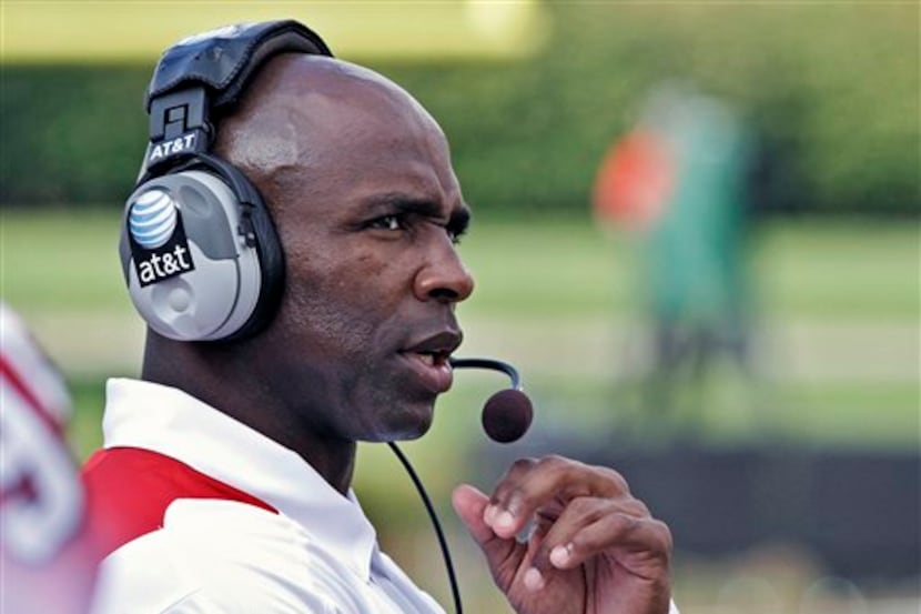 First-year Louisville coach Charlie Strong watches his team and listens to assistants in the...