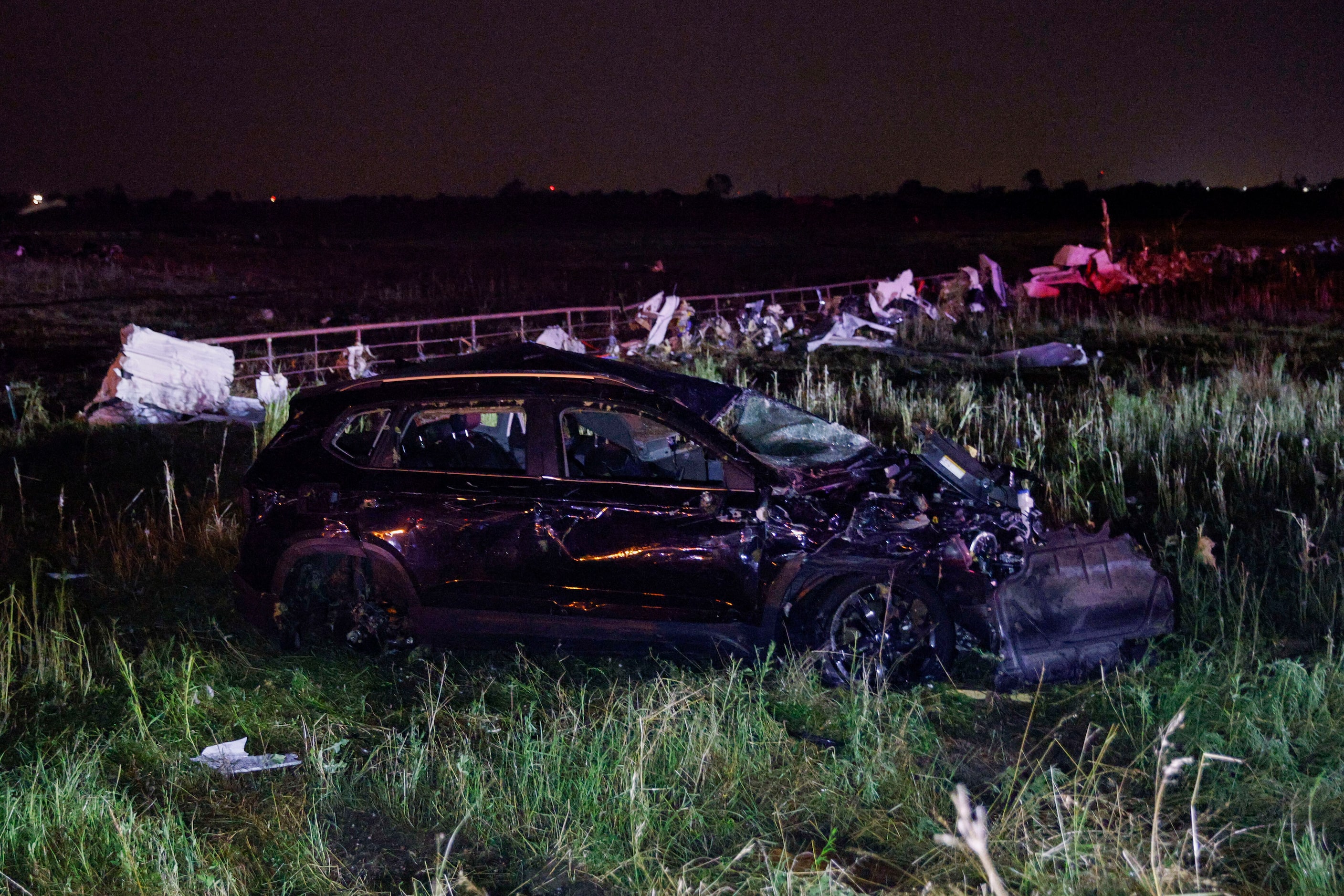 An SUV is seen in a field near a Shell gas station after a suspected tornado moved through...