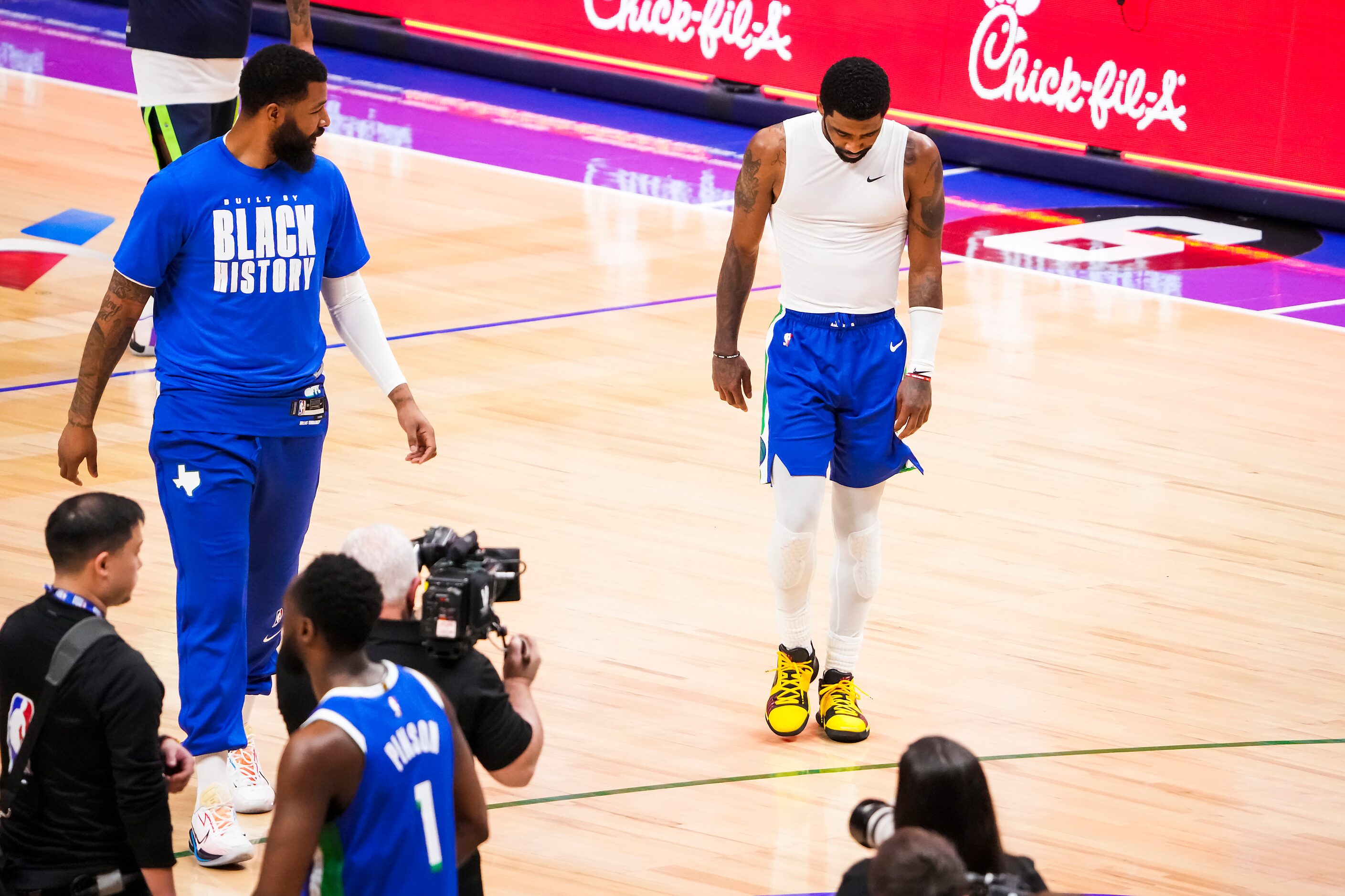 Dallas Mavericks guard Kyrie Irving (right) and forward Markieff Morris leave the court...