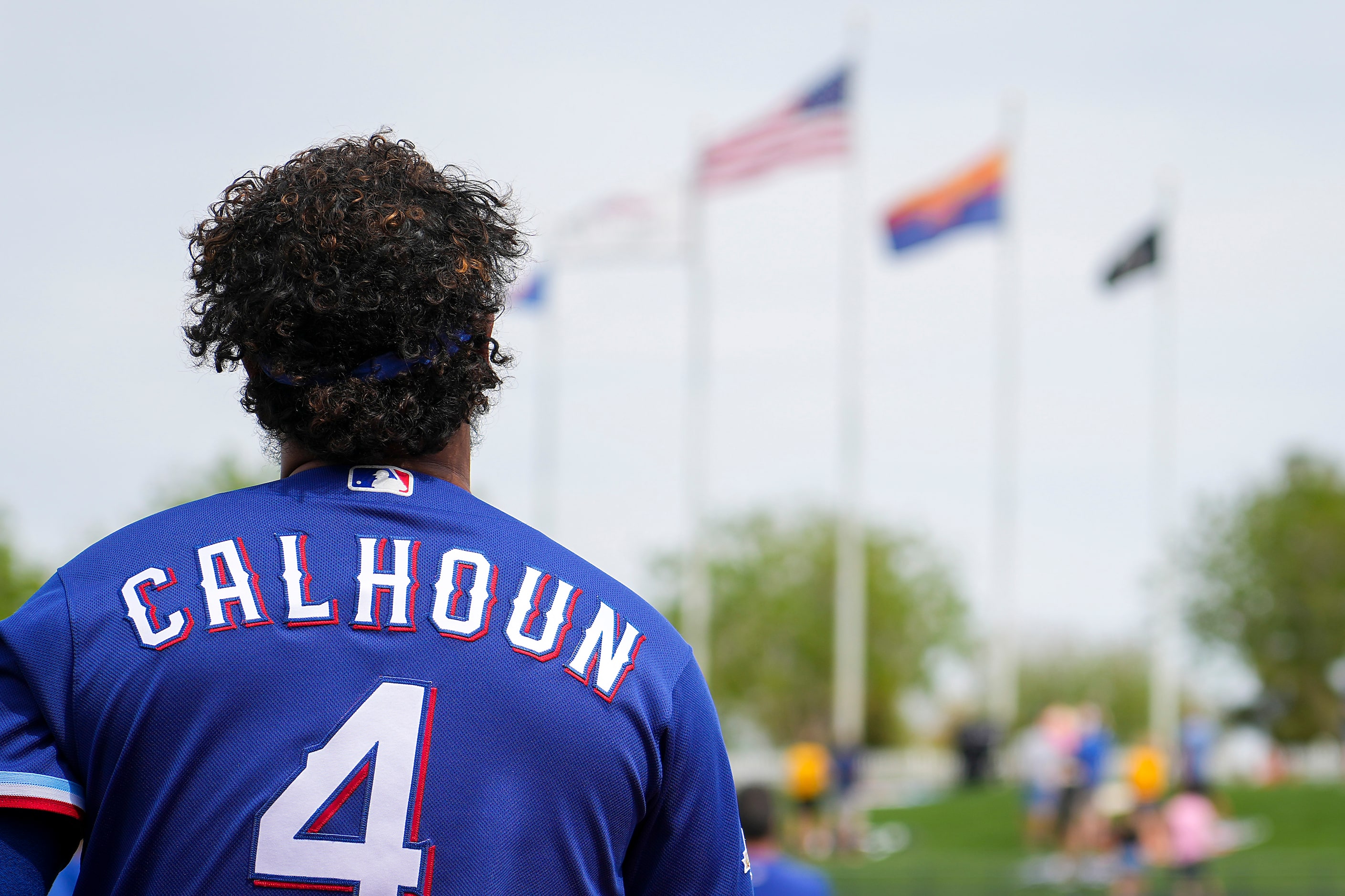 Texas Rangers outfielder Willie Calhoun stands for the national anthem before a spring...