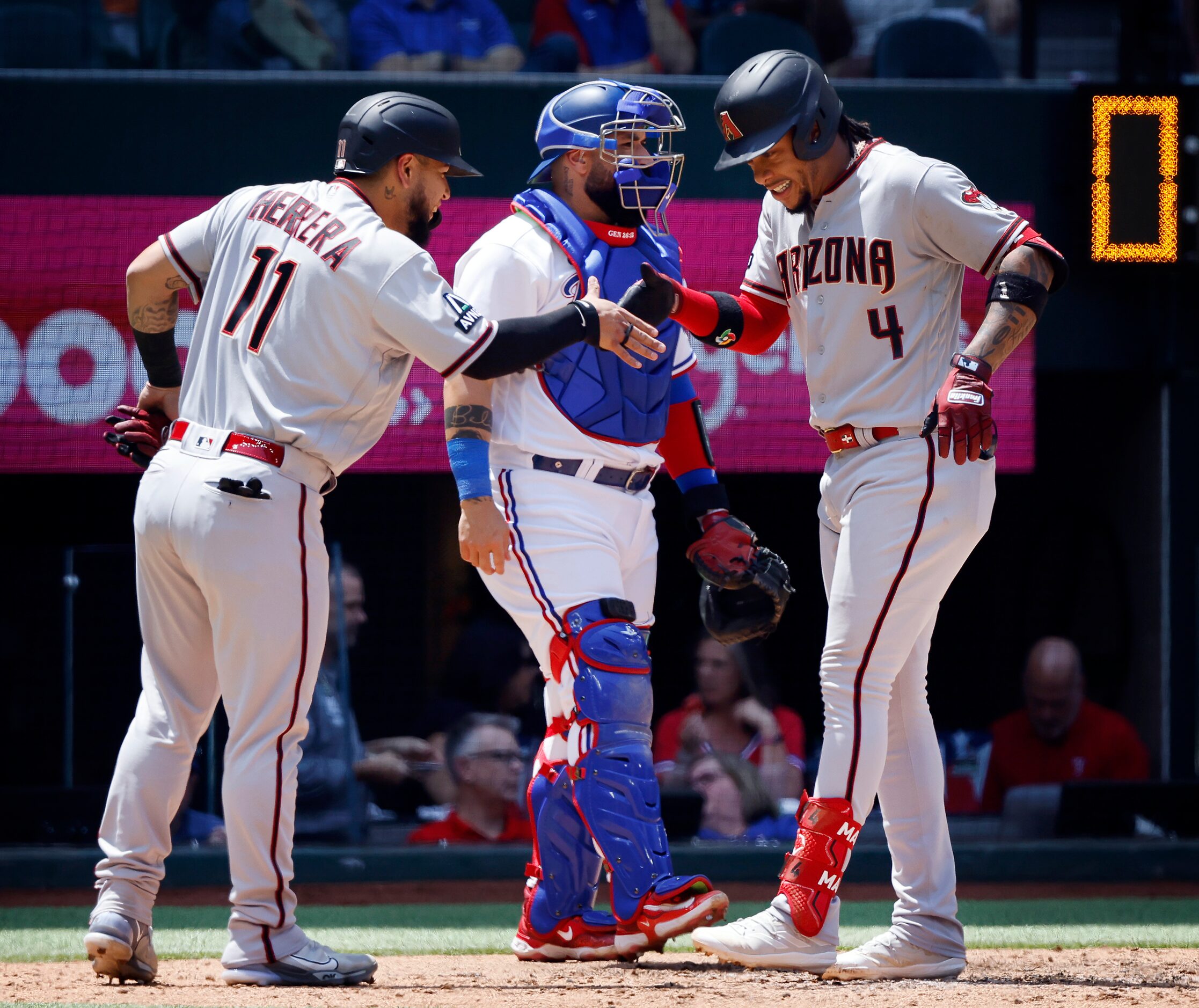 Before Texas Rangers catcher Sandy Leon (center), Arizona Diamondbacks Ketel Marte (4) is...