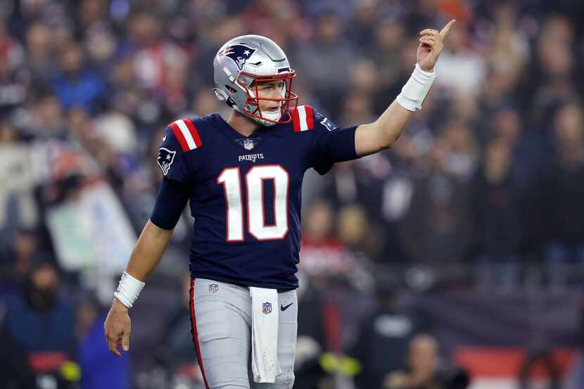 New England Patriots quarterback Mac Jones gestures during the first half of an NFL football...