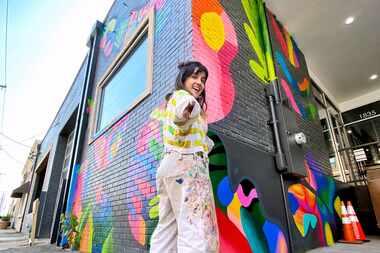 Mariell Guzman poses in front of her mural collaboration with Dallas-based company LDF Silk.