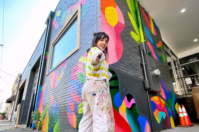 Mariell Guzman poses in front of her mural collaboration with Dallas-based company LDF Silk.