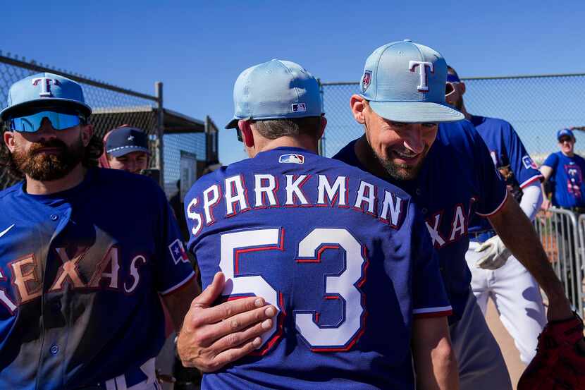 Texas Rangers pitcher Nathan Eovaldi hugs Kevin Sparkman of Dude Perfect during a spring...