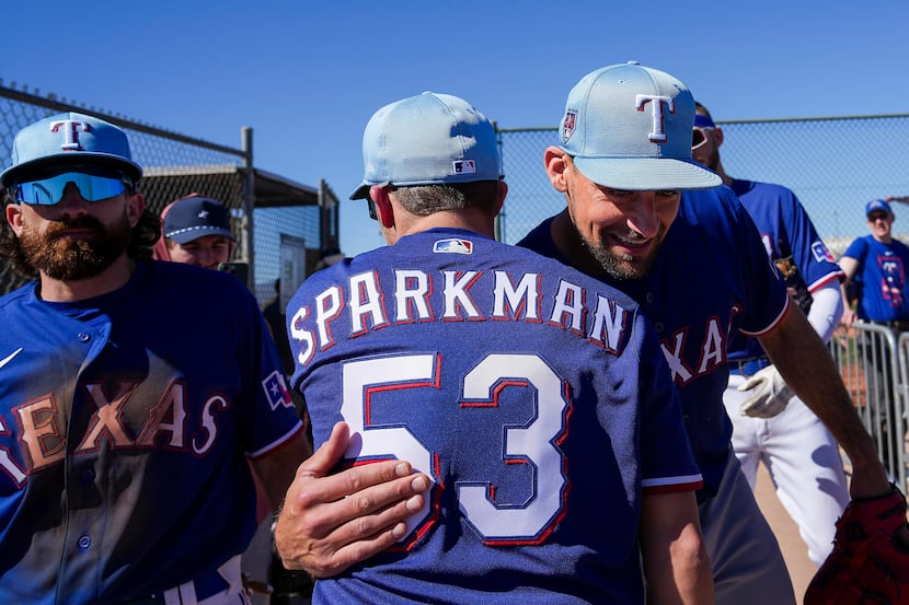 Texas Rangers pitcher Nathan Eovaldi hugs Kevin Sparkman of Dude Perfect during a spring...