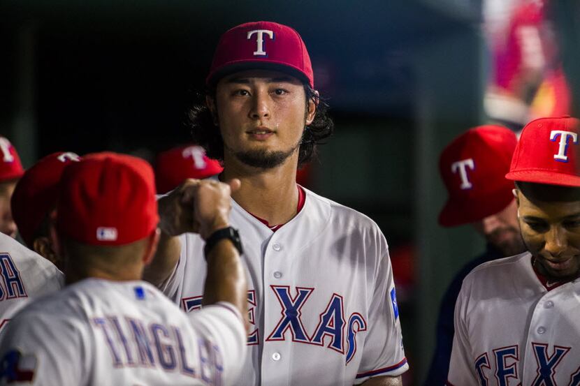 Texas Rangers starting pitcher Yu Darvish (11) gets fist bumps from teammates in the dugout...