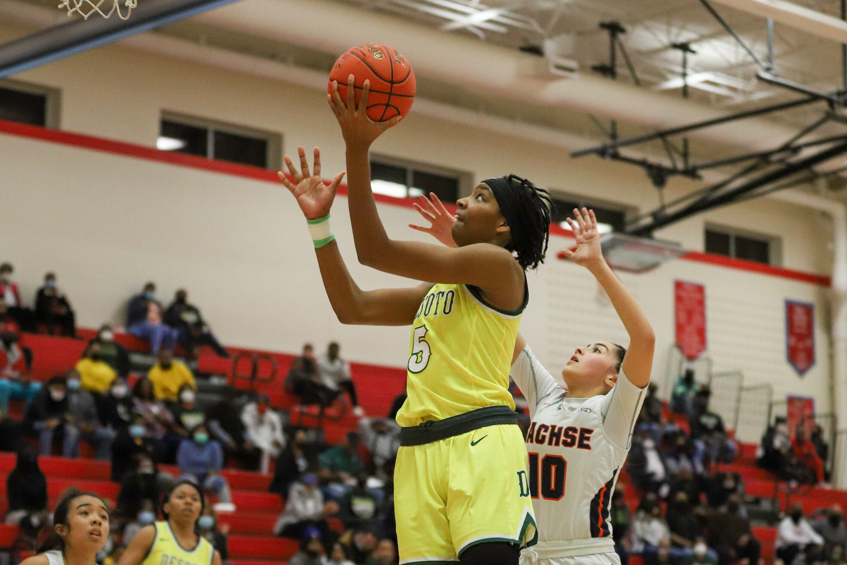 Desoto’s Sa’Myah Smith (5) attempts a layup over Sachse’s Brianna Salazar (10) during the...