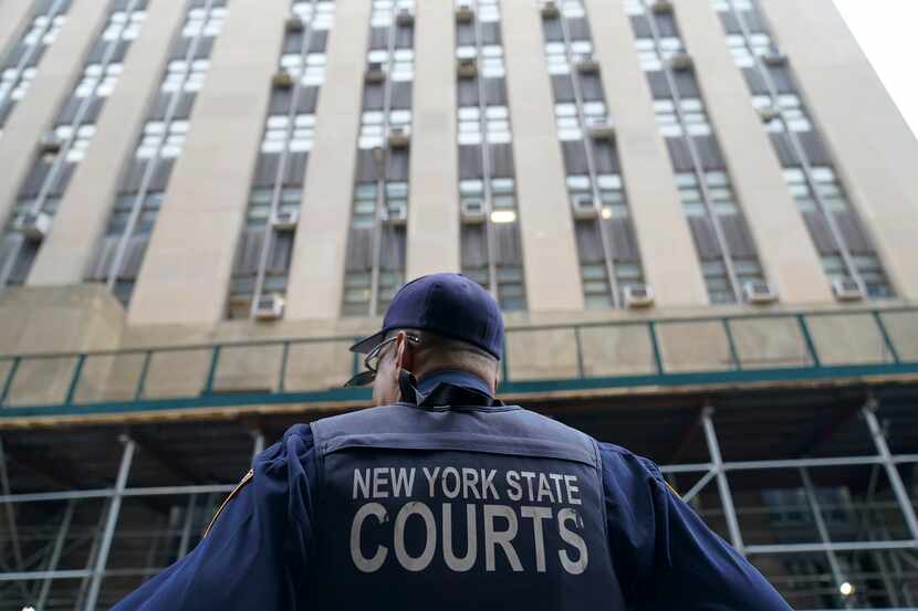 A New York State court officer stands guard outside the district attorney's office Wednesday...