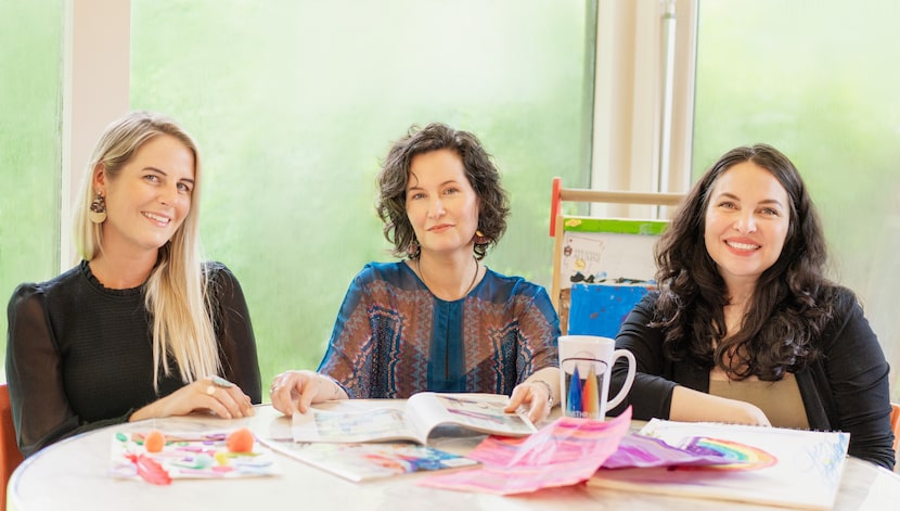 Christianne Green, LIz Jordan and Sarah Creasman Barnett sit at a table surrounded by pieces...