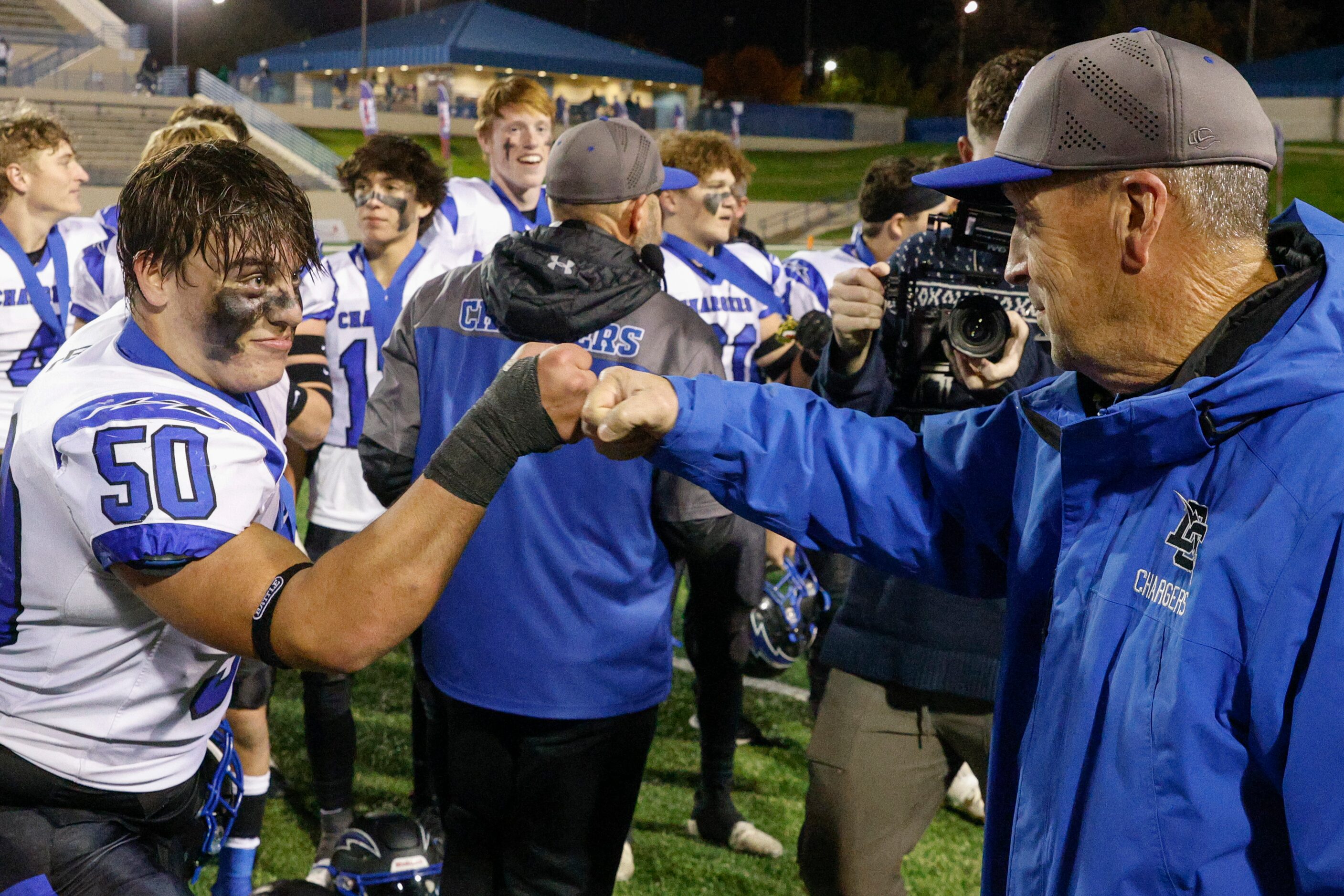 Dallas Christian offensive lineman Porter Nix (50) fist bumps Dallas Christian head coach...