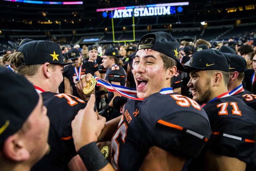 Aledo offensive lineman Cayden Glasgow (56) holds up his gold medal as he and his team...