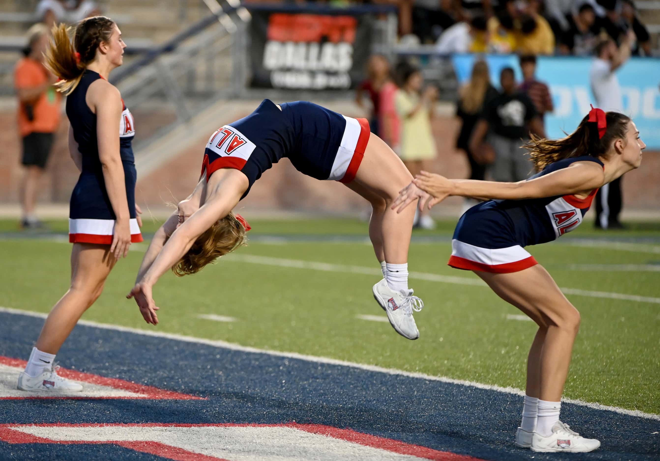 Allen cheerleaders do backflips in the endzone after a touchdown in the first half during a...