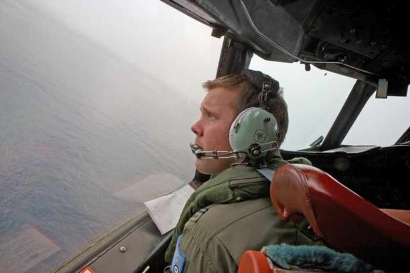 
Marc Smith of the Royal Australian Air Force helps fly an AP-3C Orion aircraft searching...