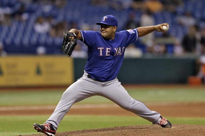 Texas Rangers relief pitcher Joe Ortiz delivers to the Tampa Bay Rays during the 12th inning...