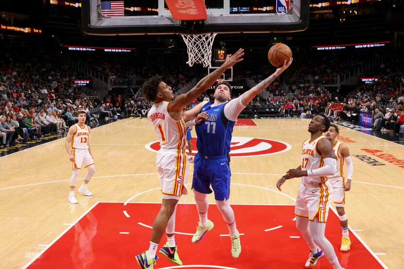 Dallas Mavericks guard Luka Doncic (77) attempts to shoot against the defense of Atlanta...
