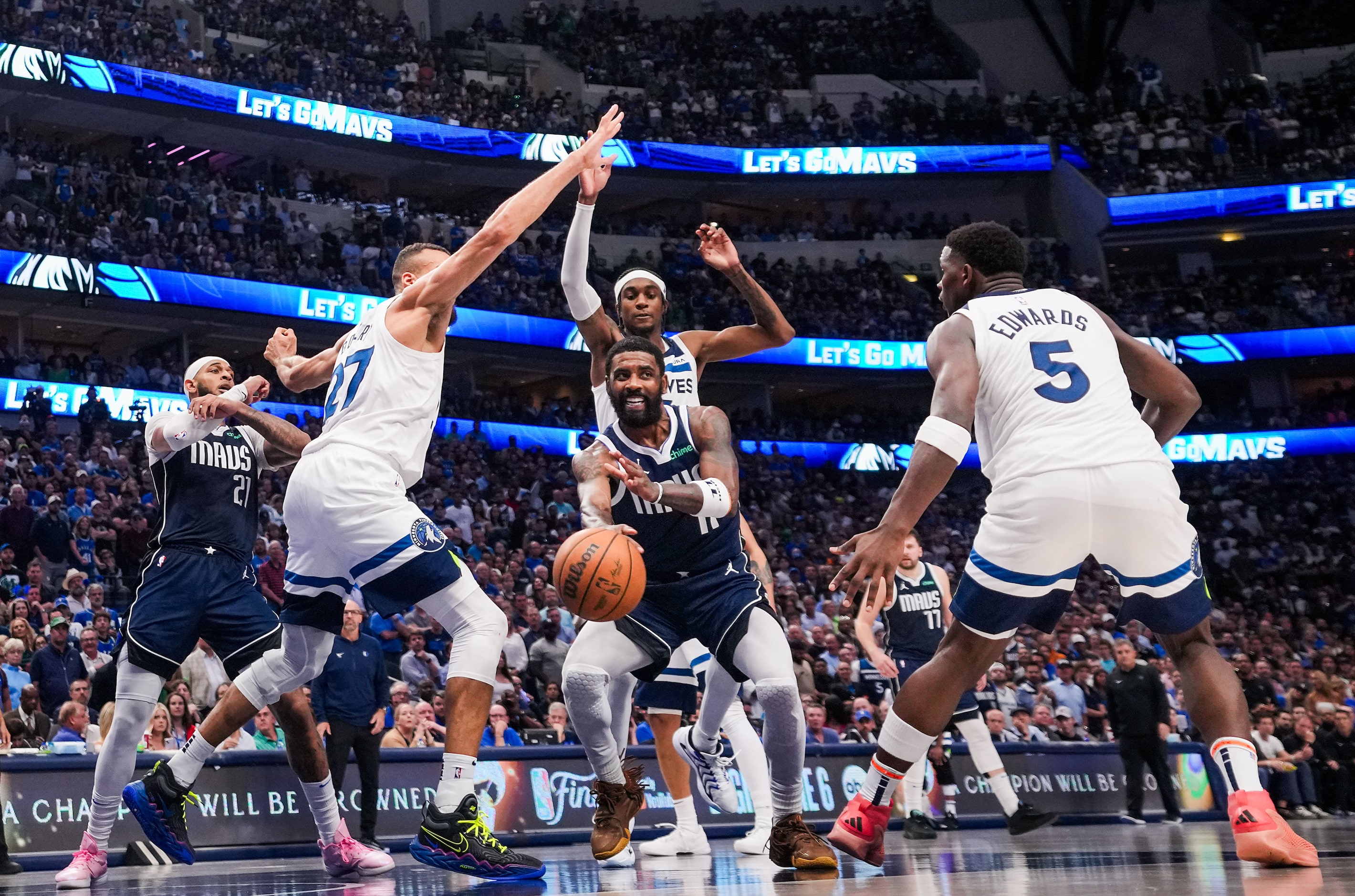 Dallas Mavericks guard Kyrie Irving (11) passes the ball between Minnesota Timberwolves...