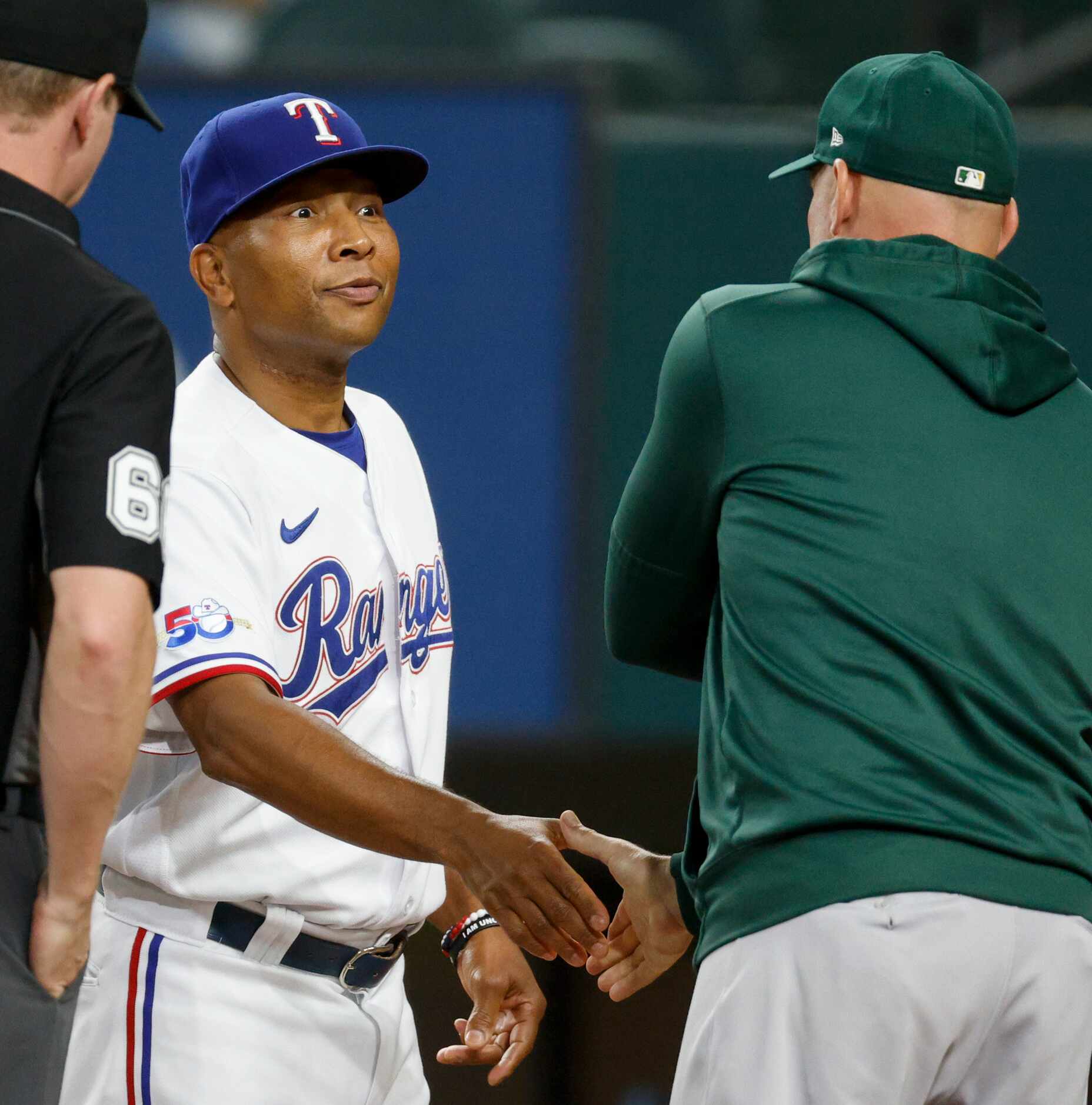 Texas Rangers interim manager Tony Beasley (27) shakes hands with Oakland Athletics manager...