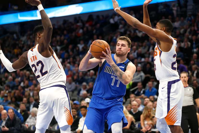 Dallas Mavericks guard Luka Doncic (77) looks to pass as Phoenix Suns center Deandre Ayton...