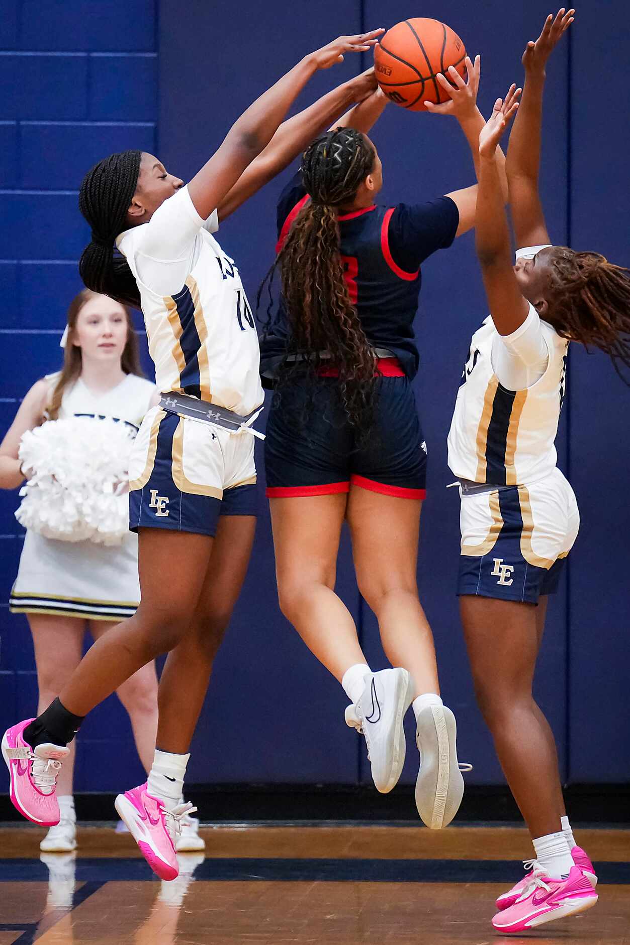 Little Elm's Amina Diallo (left) and Kam Williams defend a shot by Allen’s Aryn Roberts (23)...