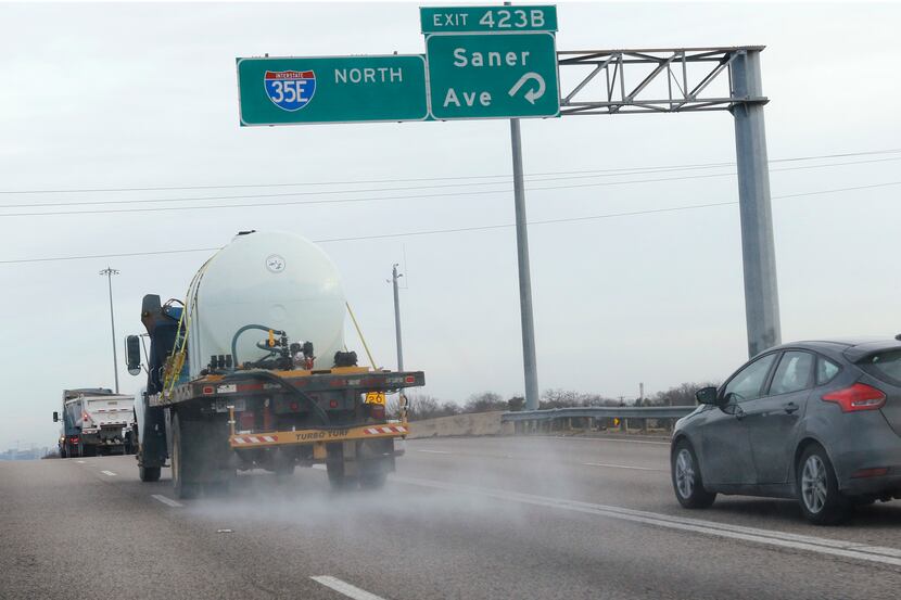 A TxDOT contractor sprays Interstate 35E with a pretreatment for ice in January.