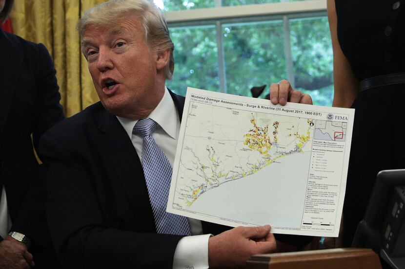 President Donald Trump holds up a diagram showing damage assessments  in the Oval Office on...