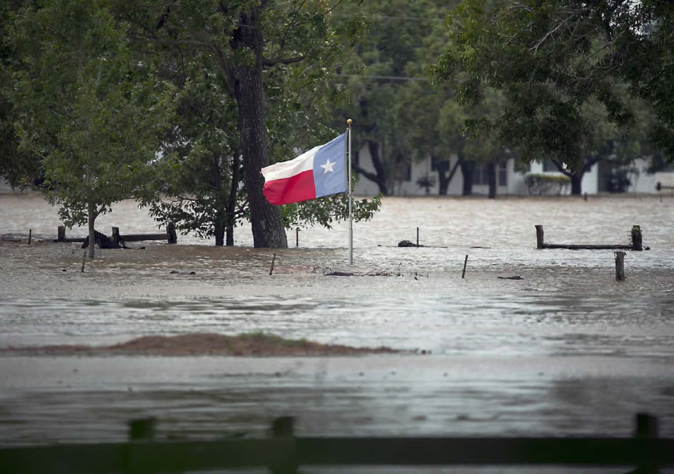 A Texas flag flies over floodwaters caused by Harvey in La Grange on Aug. 28, 2017.