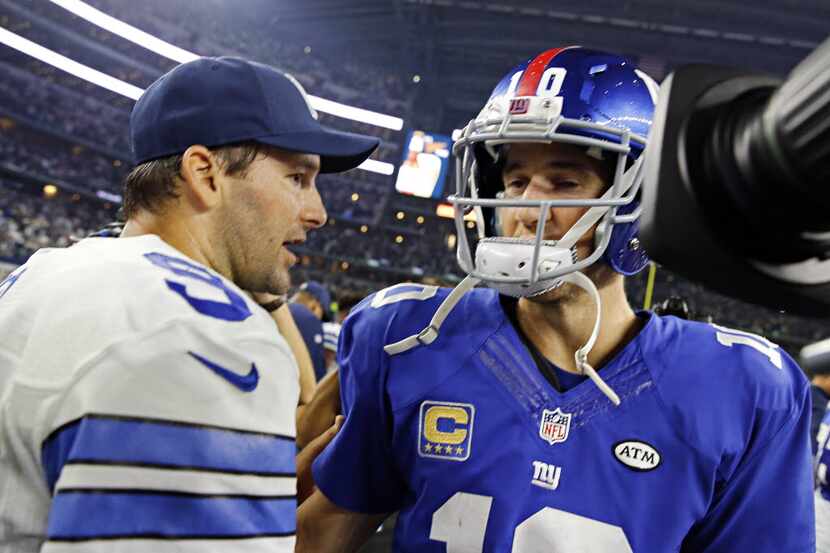 Dallas Cowboys quarterback Tony Romo (9) and New York Giants quarterback Eli Manning meet on...