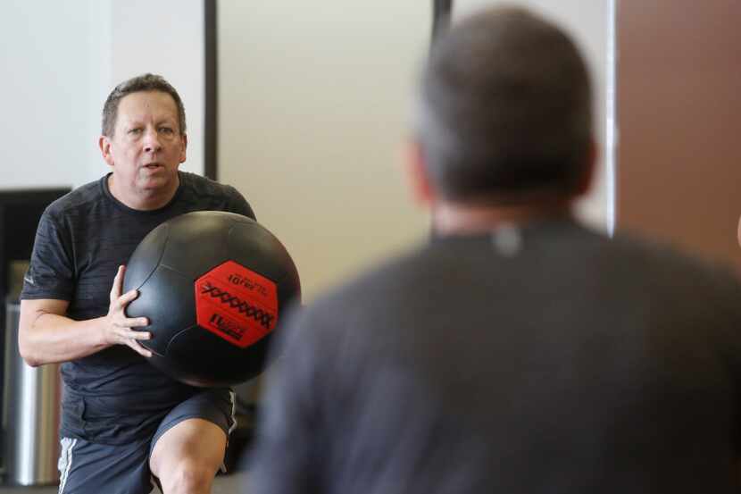 Steven Kincel works out at the overhead ball lunge station at a Core Power class at Corado...