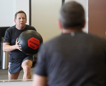 Steven Kincel works out at the overhead ball lunge station at a Core Power class at Corado...