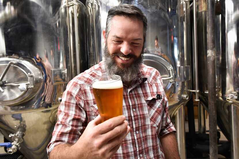 Owner Seth Morgan smiles at his first beer that has been poured at  Denton County Brewing...