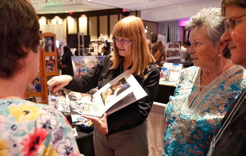 
Jan Scott of 2nd2Nunn Photography showed off a wedding portfolio to Angela King (left), the...