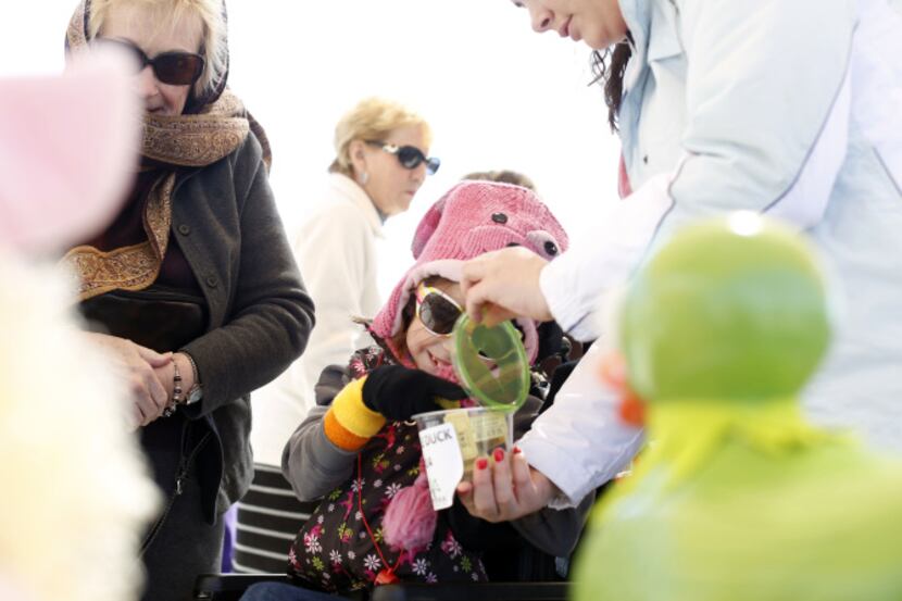Emerson Sieling (center) cast her vote for a ducky decorated as Kermit the Frog, assisted by...