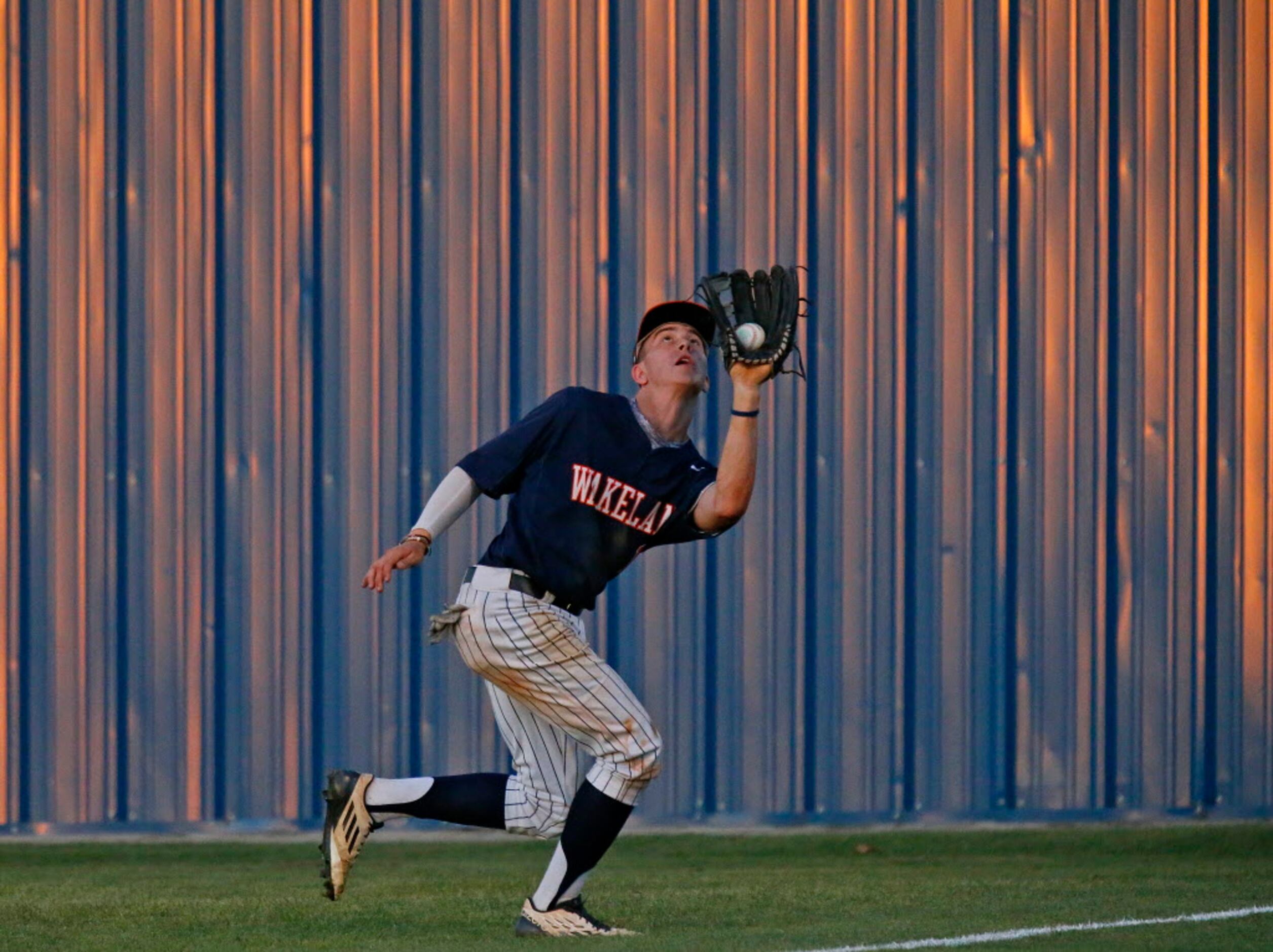 Firsco Wakeland right fielder Bryce Kozeny (18) catches a pop fly in deep right field during...