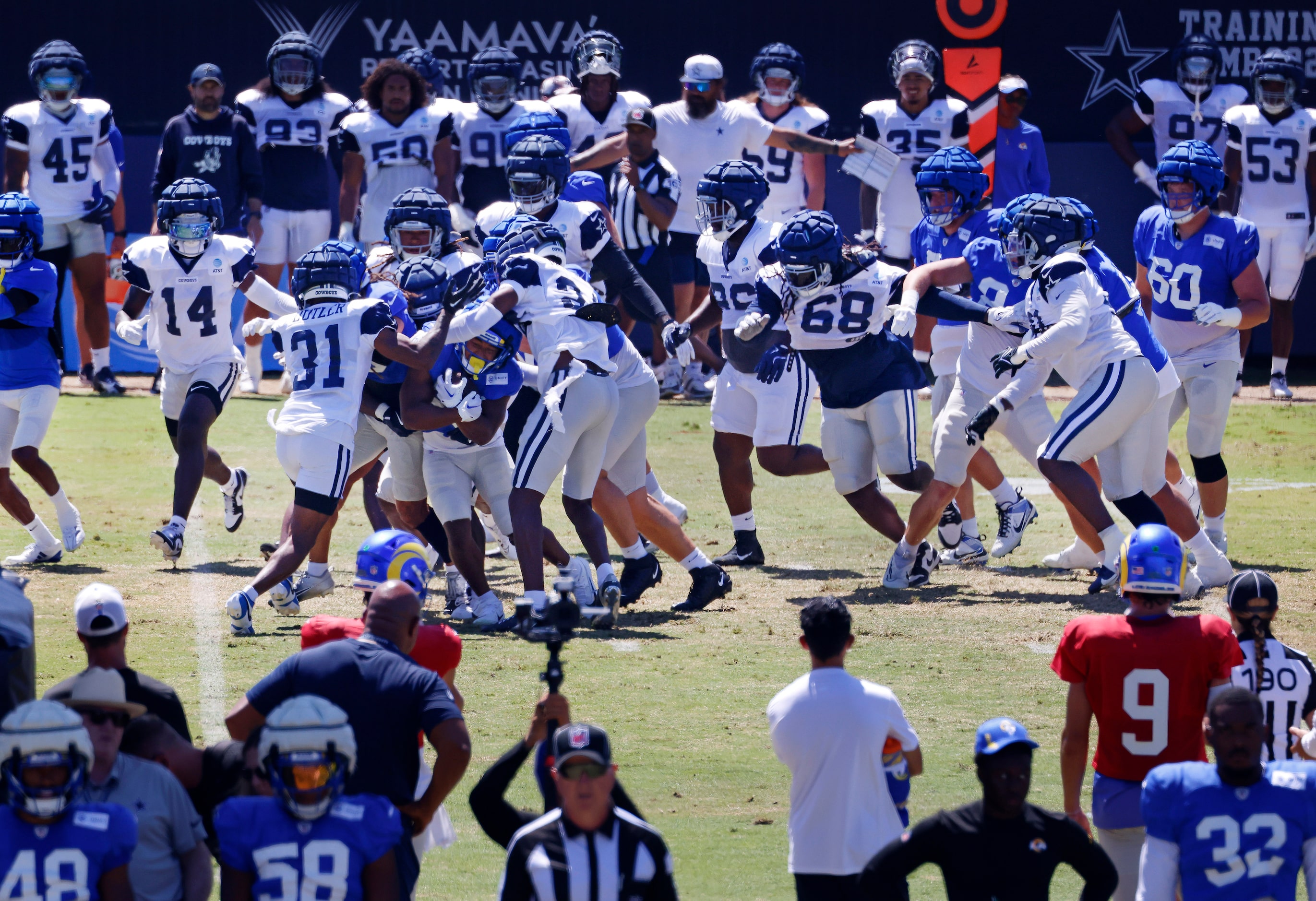 The Dallas Cowboys defense swarms a Los Angeles Rams ball carrier during a training camp...