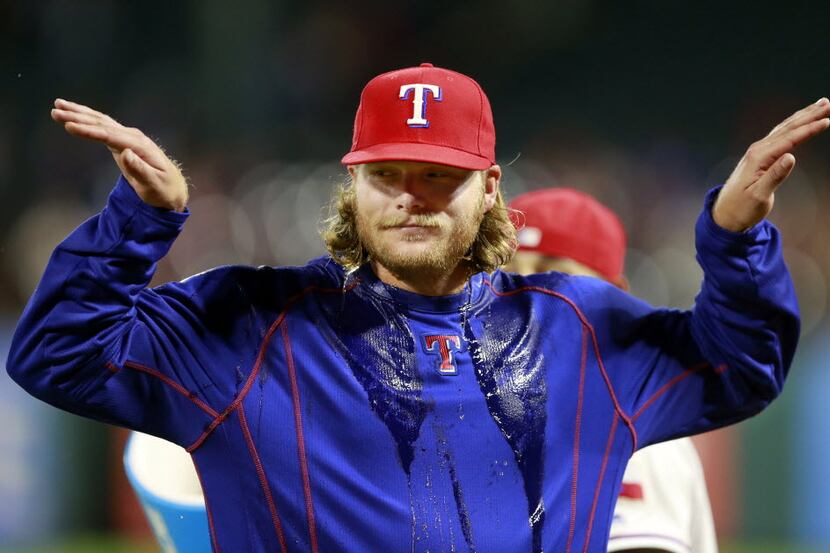 Texas Rangers starting pitcher A.J. Griffin gestures after receiving the postgame gum ball,...