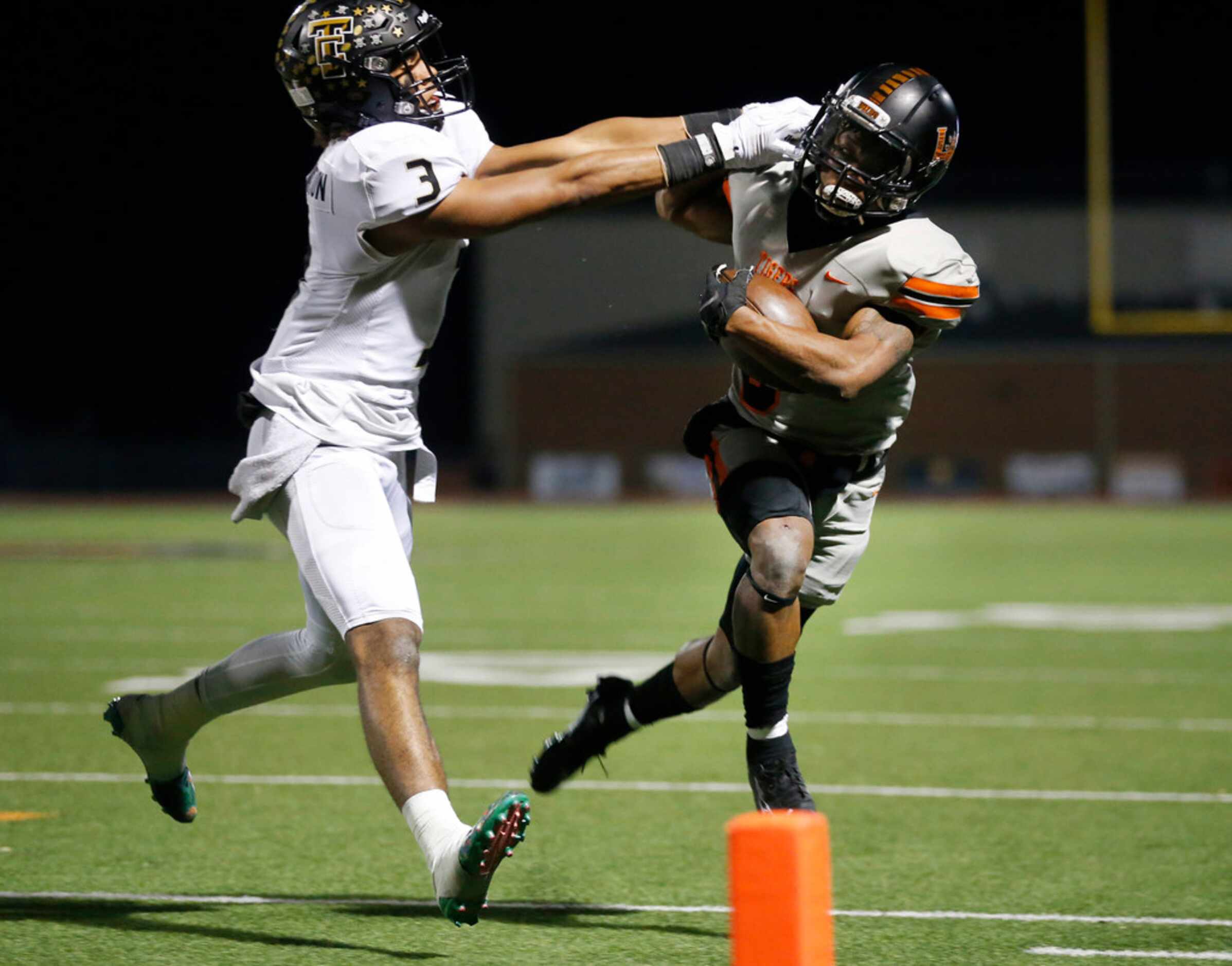 The Colony cornerback Christian Gonzalez (3) pushes Lancaster running back DQ James out of...