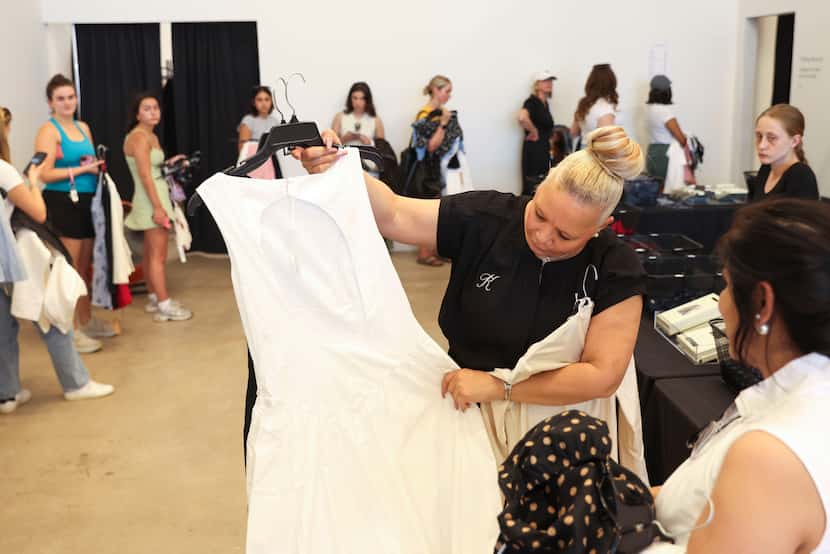 Store manager Katrina Guidry (left) shows a dress to a customer at 260 Sample Sale Friday,...