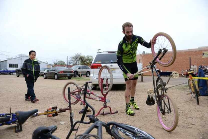 
Earn-a-Bike volunteer Jacob Salassi gets ready to help James Alfaro, 9, fix a used bike. 
